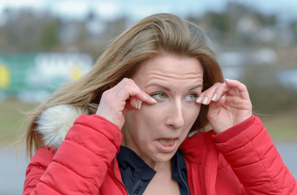 A woman outdoor on winter day is wiping her watery eyes