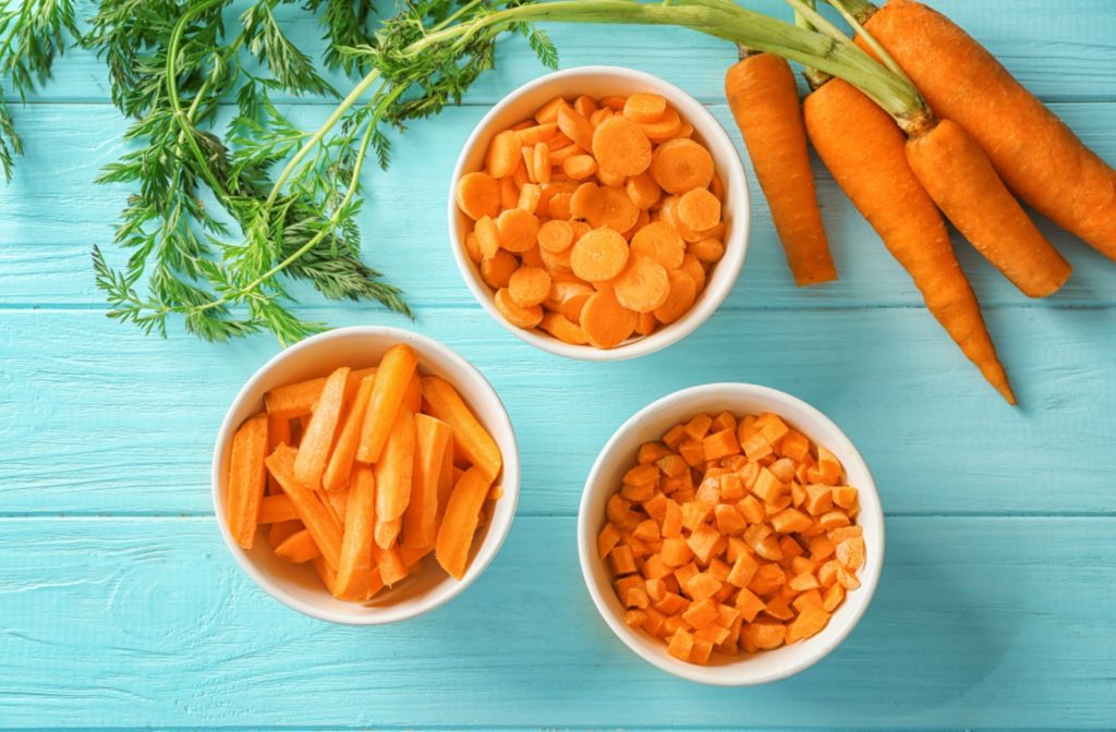 Three bowls of carrots chopped up in different ways