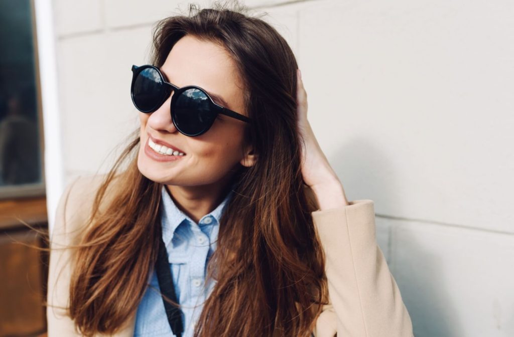 A woman smiling while wearing prescription sunglasses