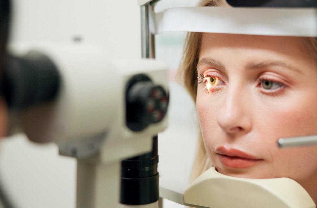 An optometrist examines a patient's eye using a slit lamp.